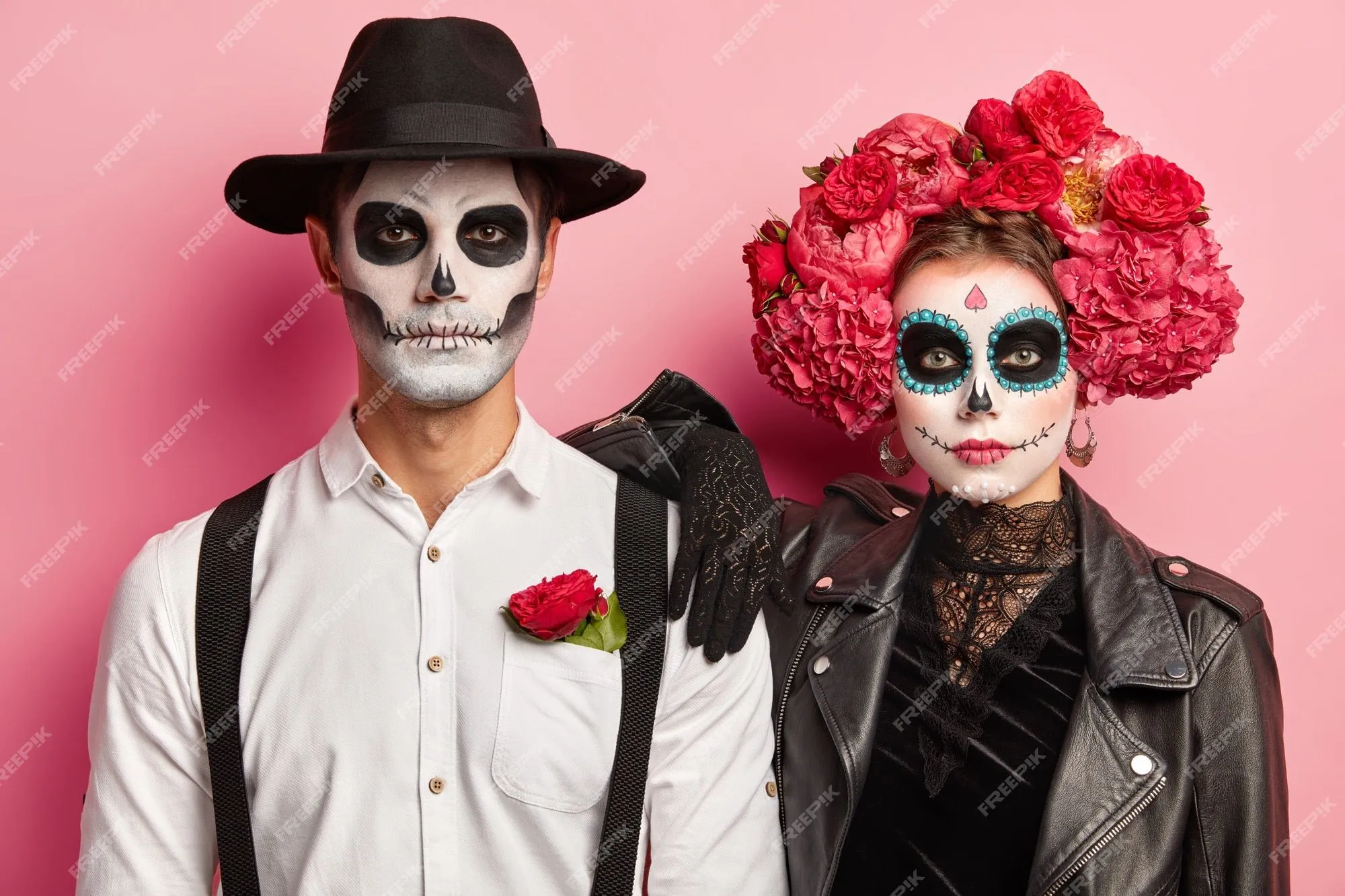 Disparo horizontal de una pareja espeluznante vestida para el día de  muertos en méxico, usar máscaras de calaveras, estar uno al lado del otro,  celebrar halloween juntos, aislado sobre fondo rosa |