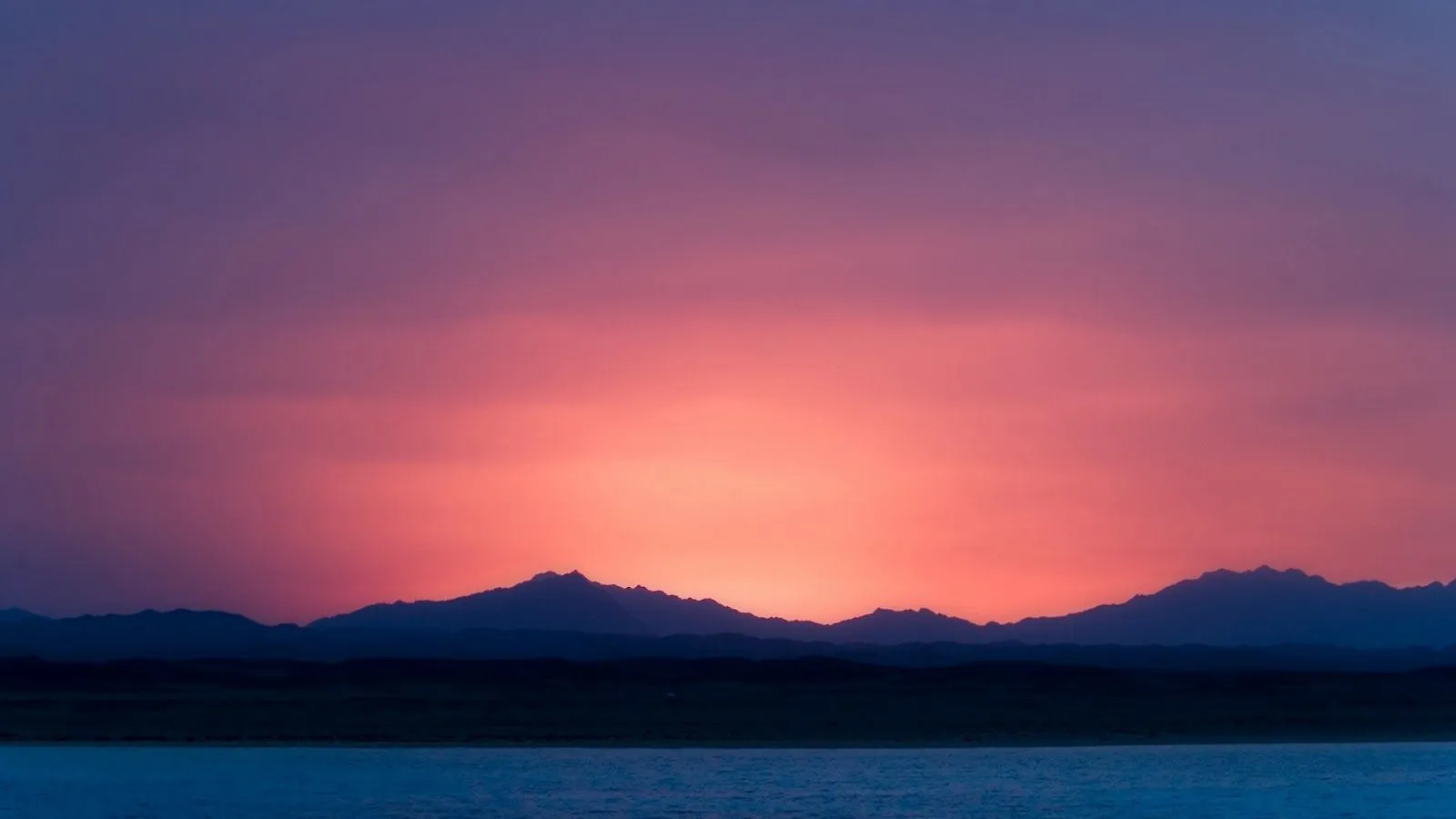 Bello de atardecer de colores cálidos por detrás de las montañas ...