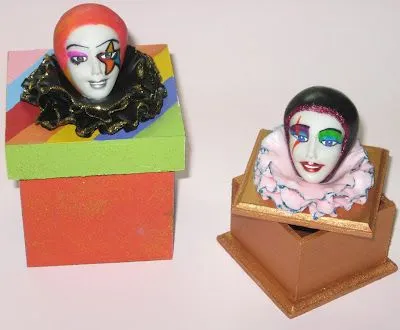 Cajas con caras de mujer pintadas como payaso