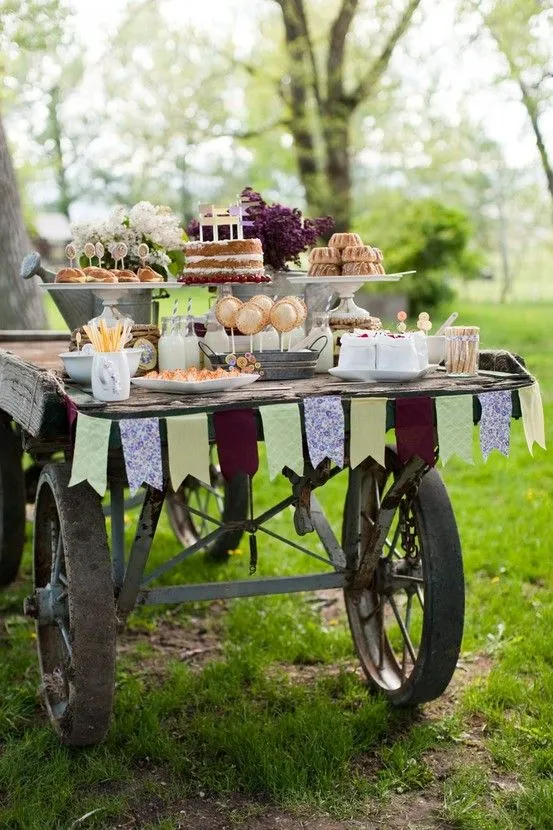 Un carrito con dulces y banderines, perfectos para decorar tu boda –