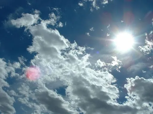 Nubes blancas sobre cielo azul y sol