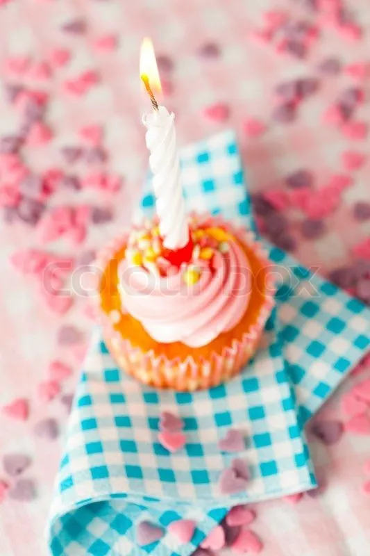 Close-up of a pink muffin with party candle stock photo