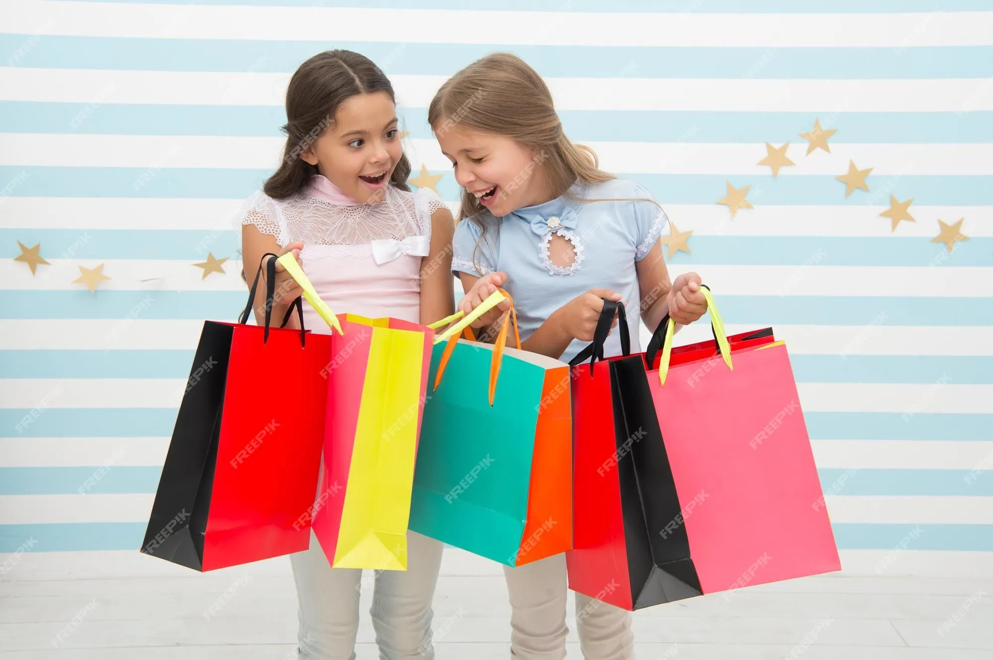 Concepto de descuento. las niñas lindas de los niños tienen bolsas de la  compra. temporada de compras con descuento. pasando un buen rato juntos. los  niños satisfechos comprando fondo rayado. obsesionado con