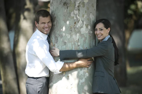 empresarios abrazando un árbol al aire libre — Foto stock ...
