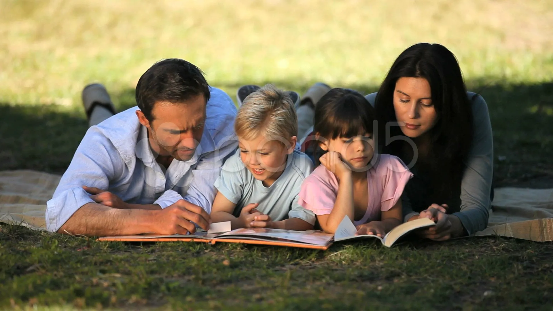 Familia Leyendo Un Libro Acostado En Un Mantel Archivos de Video ...