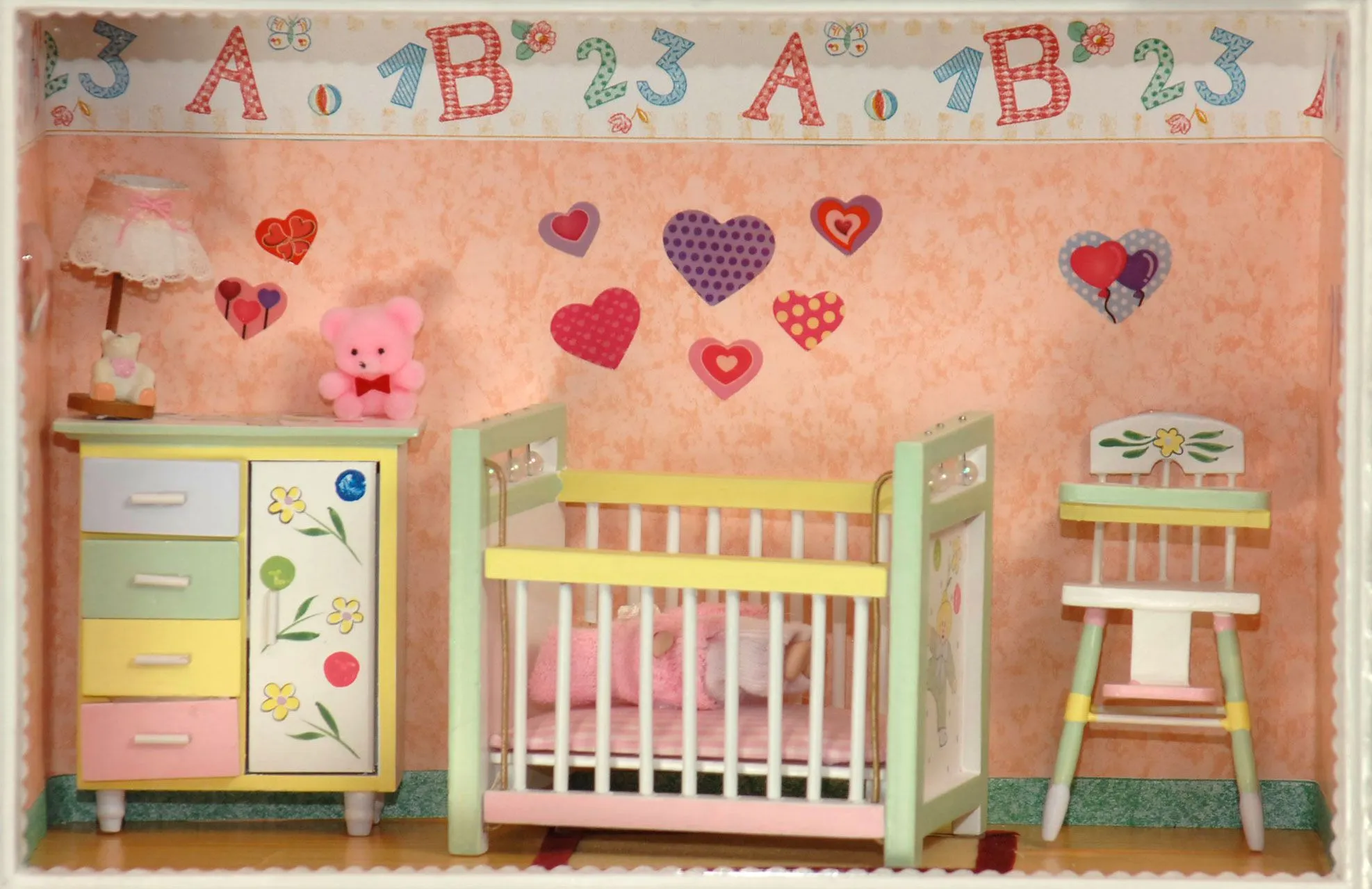 Habitación de niña con cuna, trona y mueble rosa decorado con ...