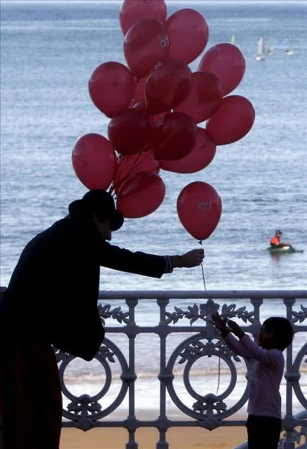 Un hombre regala un globo a un niño en el paseo de La Concha de ...