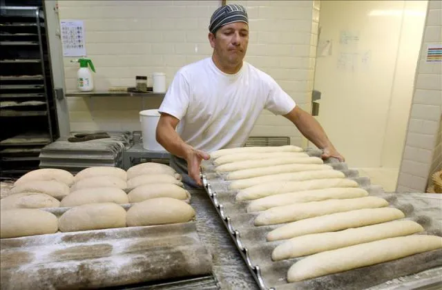 En la imagen, un panadero introduciendo la masa en el horno. EFE ...