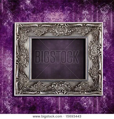 Intricate old frame hanging on grungy violet vintage wallpaper ...