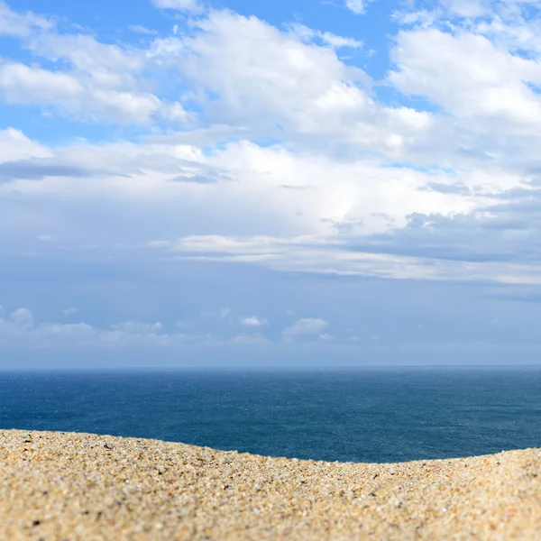 Un montón de arena en una playa contra el mar y el cielo. Listo ...