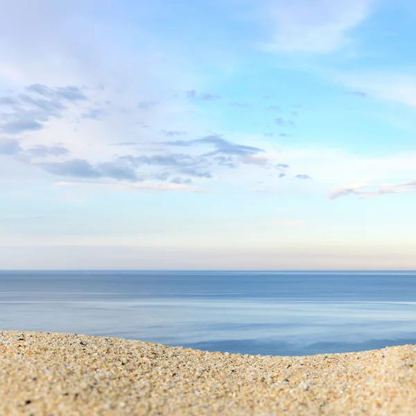 Un montón de arena en una playa contra el mar y el cielo. Listo ...