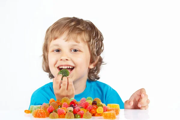 niño comiendo caramelos sobre fondo blanco — Foto stock © borusikk ...