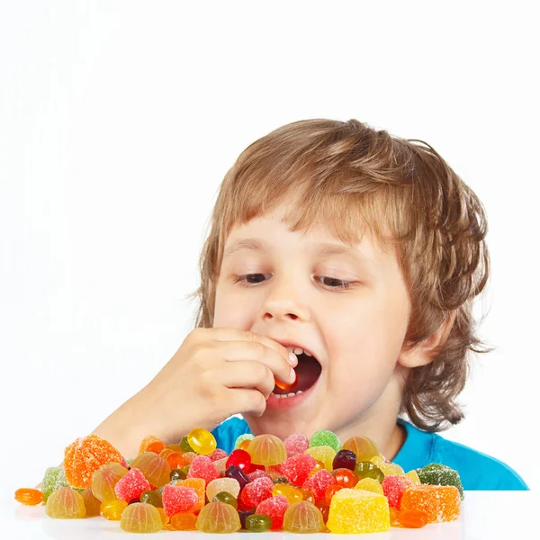 niño comiendo caramelos de la jalea color sobre fondo blanco ...