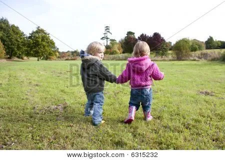 Dos niños agarrados de la mano caminando en el país Fotos stock e ...