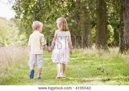 Dos niños caminando agarrados de la mano de camino Fotos stock e ...