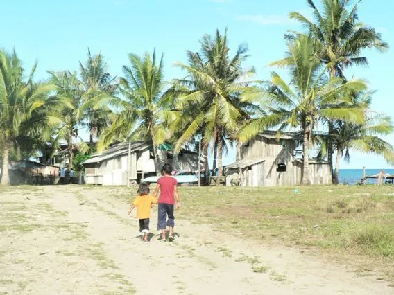 Niños caminando hacia la casa en la aldea de Kampung Sinakut: el ...