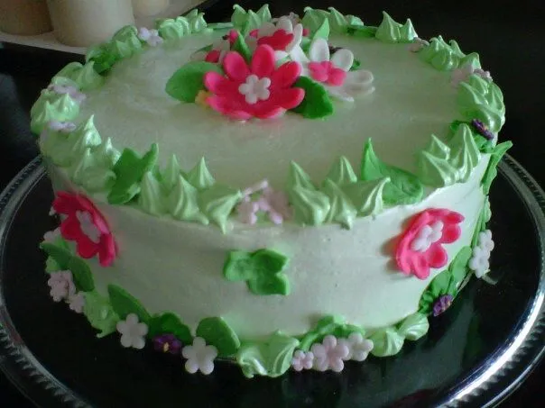 Pastel cubierto de merengue y decorado con flores de fondant y ...