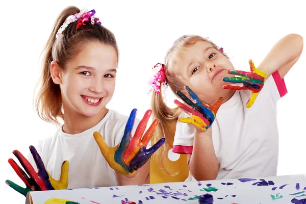 Retrato de dos niñas alegres mostrar sus manos pintadas en colores ...