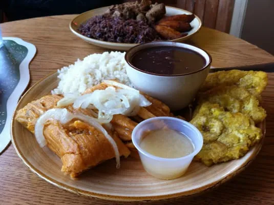 Tamales, Tostones, Rice & Black Beans. Background: Lechon Asado ...