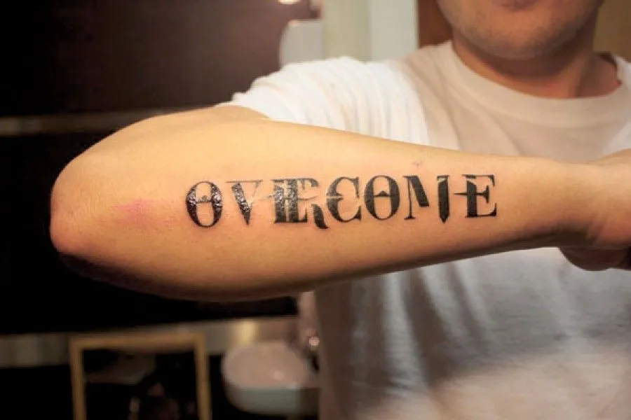 TATUAJE DE UNA FRASE EN EL ANTEBRAZO ENTRE DOS RUEDAS