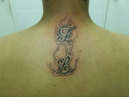 TATUAJE DE DOS INICIALES DEBAJO DE LA NUCA