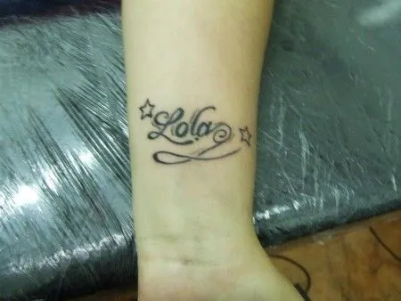 TATUAJE DE UN NOMBRE ENTRE DOS ESTRELLAS EN LA MUÑECA