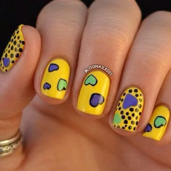 Uñas amarillas con corazones y puntos